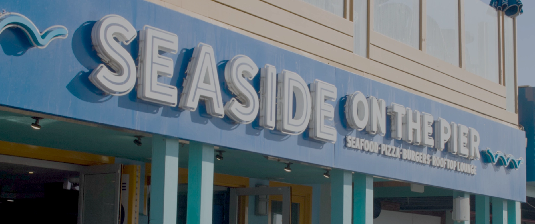The outdoor signage of a restaurant called "Seaside on the Pier"