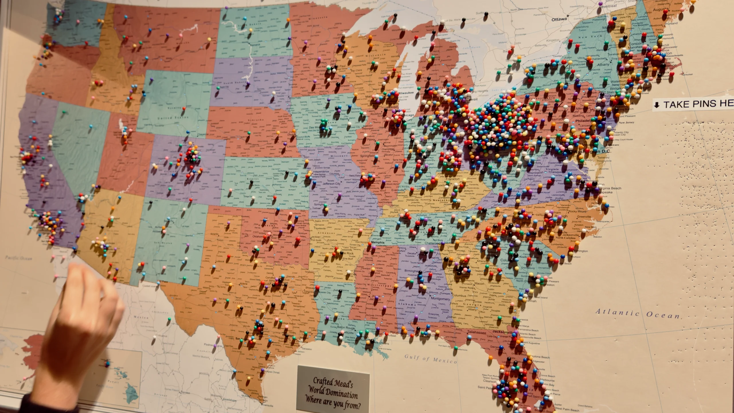 United States map covered with colorful push pins marking locations across the country